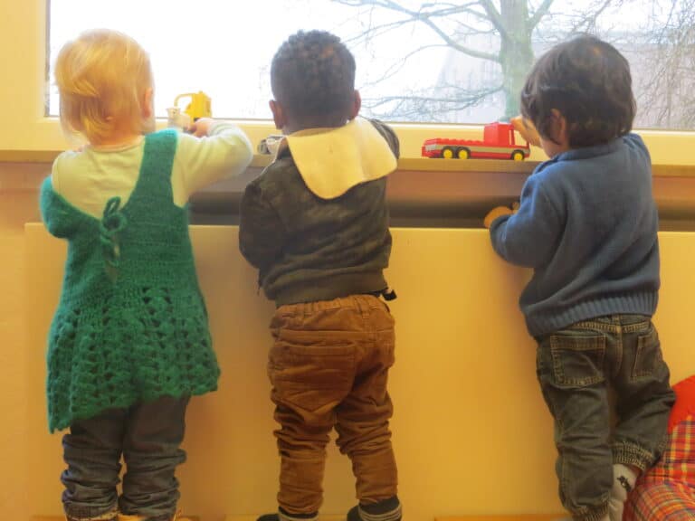 Kinder spielen am Fenster
